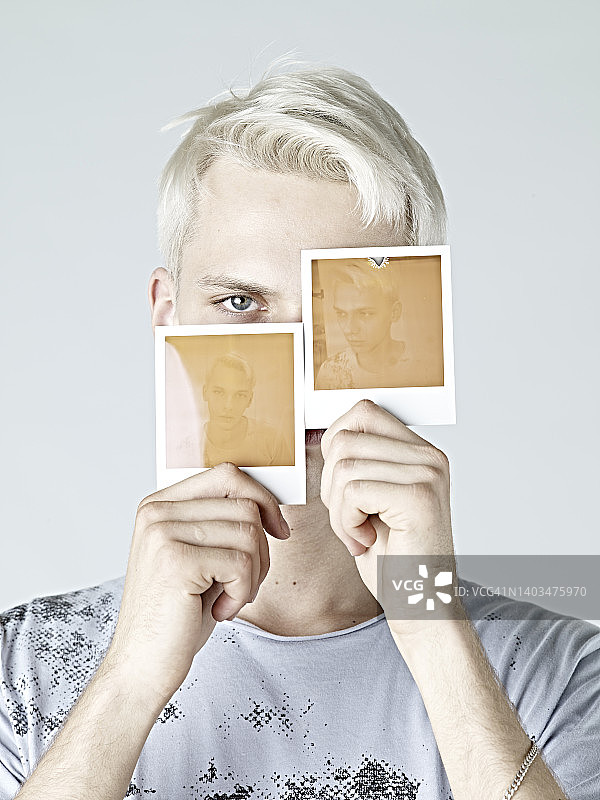 用一次成像相机自拍的年轻男人图片素材