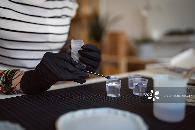 混合环氧树脂和紫色闪粉的白人手工艺人图片素材