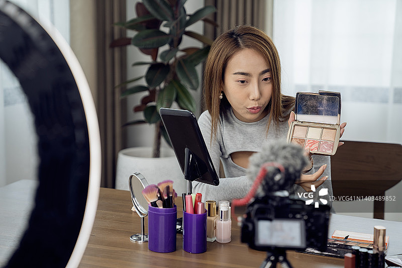 年轻女人在家拍摄美妆博客视频图片素材