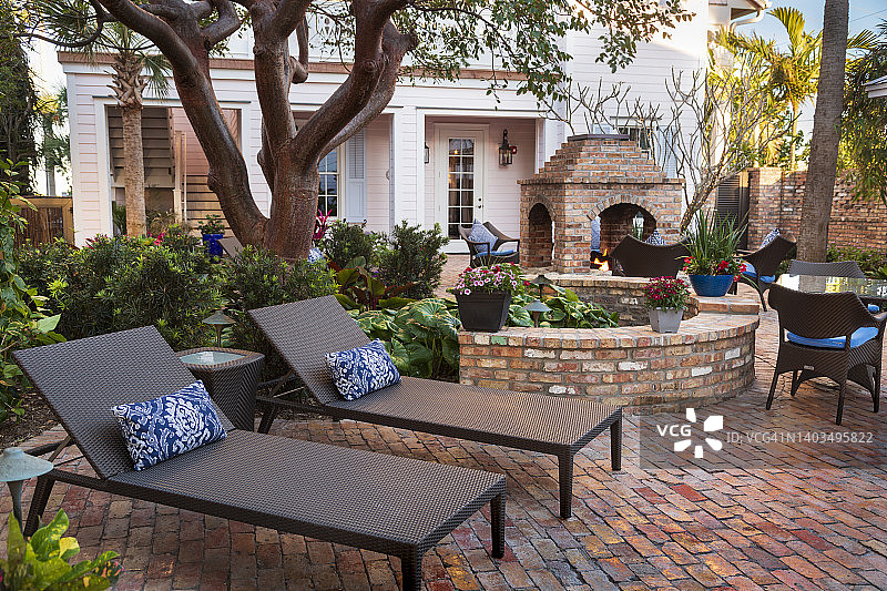 庭院家居花园的两个躺椅，带砖墙和火坑图片素材