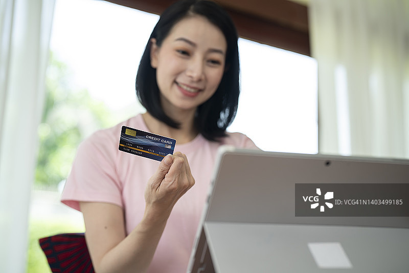 女商人用笔记本电脑和信用卡在网上购物图片素材