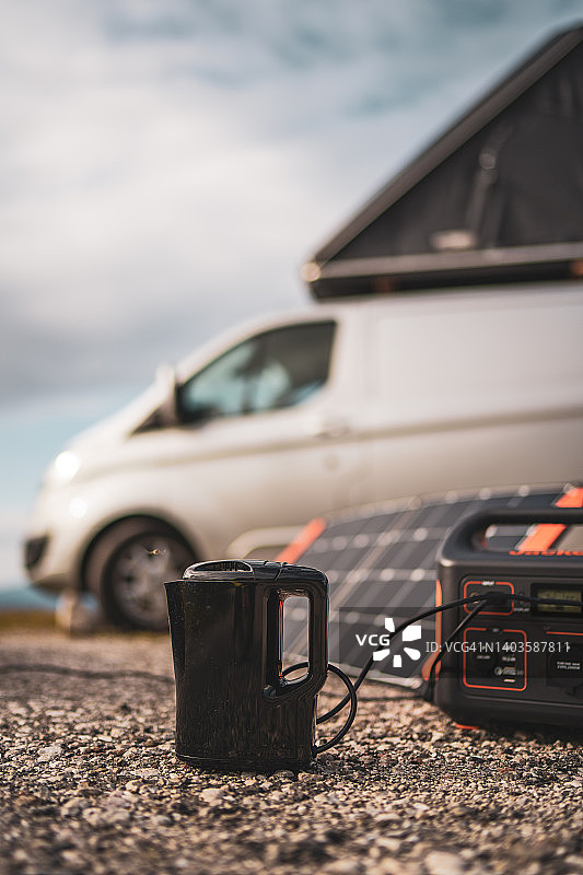 露营度假时用便携式太阳能板给水壶充电图片素材