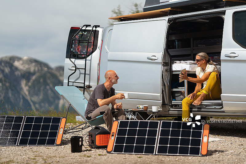 年长夫妇在山区露营早餐时计划徒步旅行图片素材