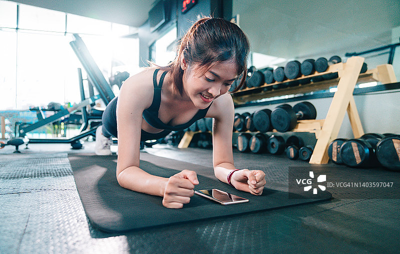 健身房女孩手机指导训练图片素材