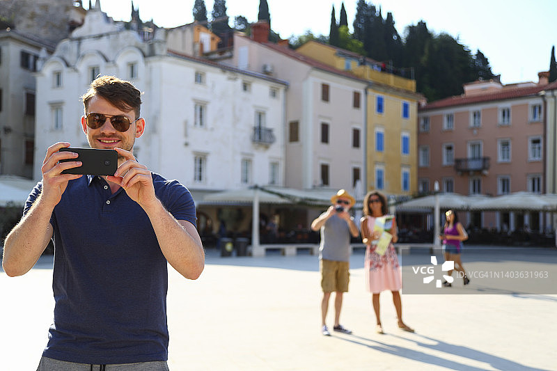 在城镇广场拍照的游客图片素材