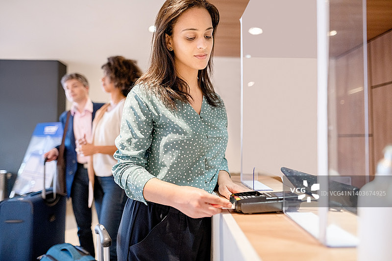 女商人在酒店前台办理入住并用信用卡付款图片素材