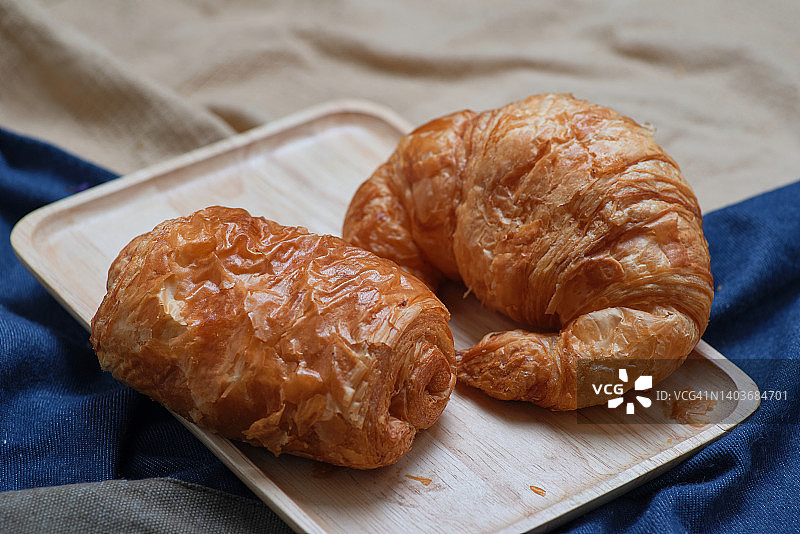 放在木托盘上的蓬松可颂和馅饼图片素材