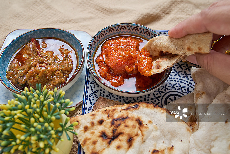 将印度薄饼蘸入印度食物图片素材
