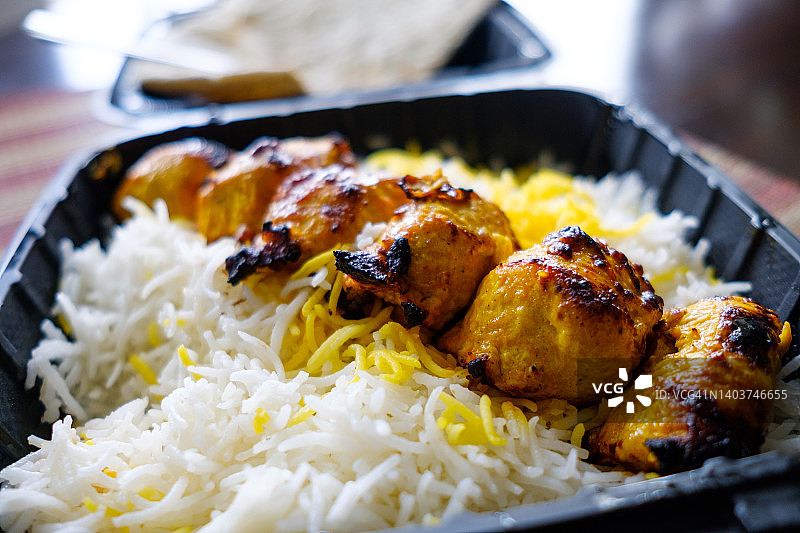 外卖容器中的波斯烤鸡肉串和米饭图片素材