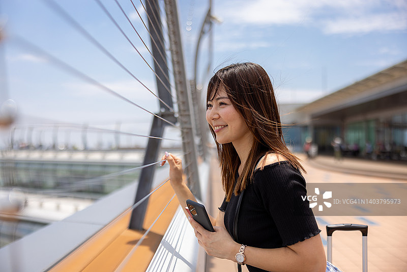 在机场观景台欣赏风景的快乐女人图片素材
