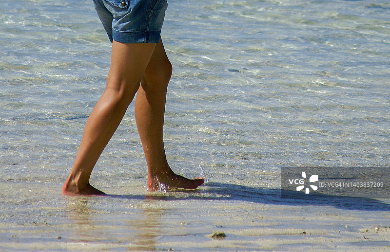 在沙滩上行走的年轻女人的腿图片素材