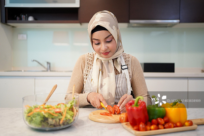 准备蔬菜的穆斯林妇女，居家烹饪的概念图片素材