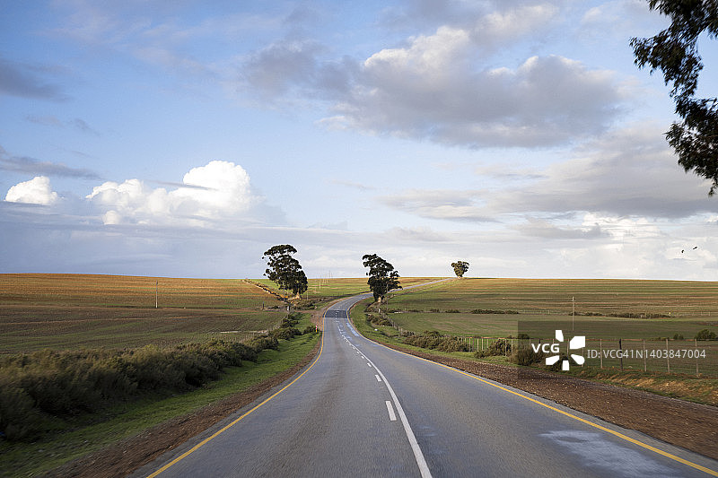 蜿蜒的道路，伴随着蓝天和白云图片素材