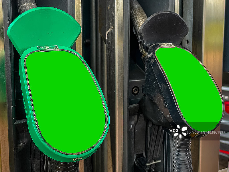 加油站汽油泵特写，带有绿色屏幕色度键营销广告牌，可替换为针对消费者、零售购物者和通勤者的营销或广告代理活动内容图片素材