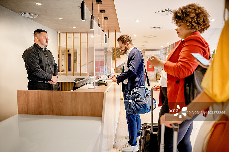 年轻商人在酒店办理入住图片素材