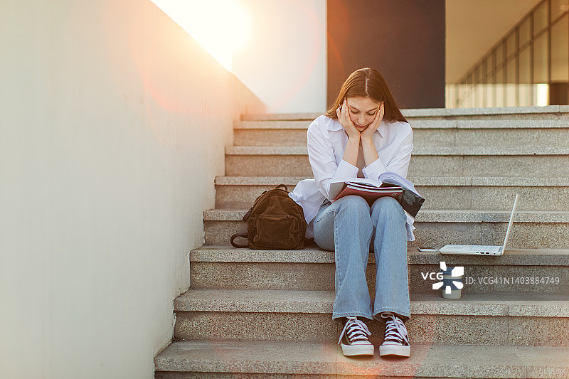 在大学建筑前学习的女学生图片素材