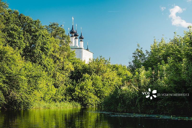 苏兹达尔夏季风景：大教堂钟楼倒映在卡缅卡河中，背景是绿树和草地。俄罗斯，弗拉基米尔地区，俄罗斯金环图片素材