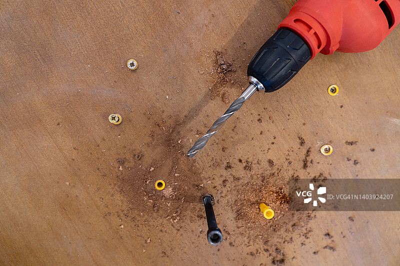 木桌家具上的钻孔工具和螺丝：组装图片素材