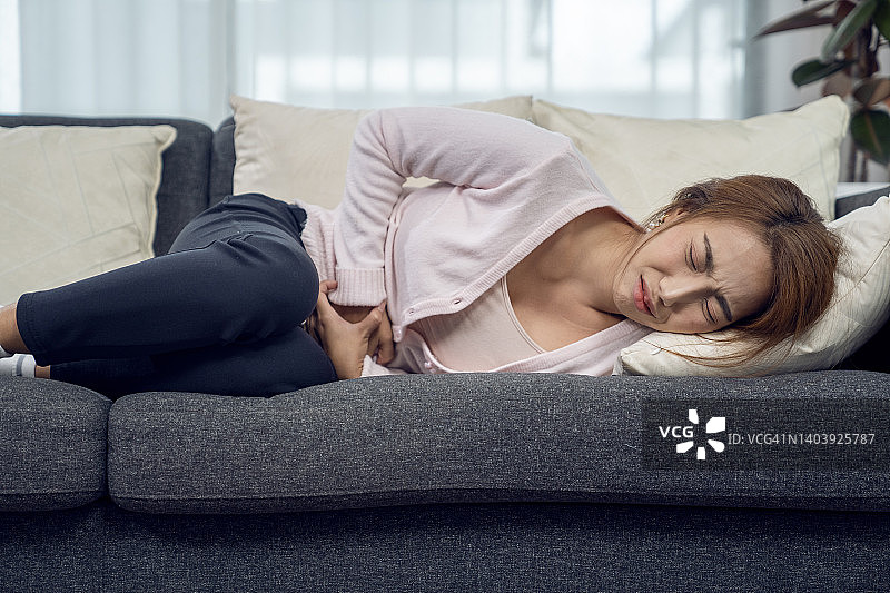 在家胃痉挛的年轻女人图片素材