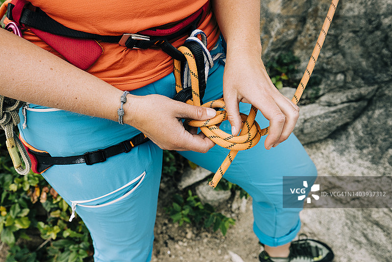 攀岩者用8字结将绳索系在安全带上特写图片素材