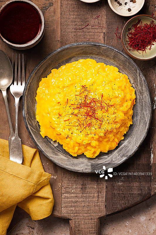 乡村木桌上的藏红花烩饭与红酒杯图片素材