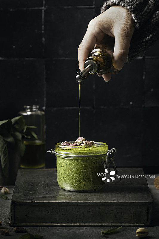 鼠尾草开心果酱玻璃罐与人手图片素材