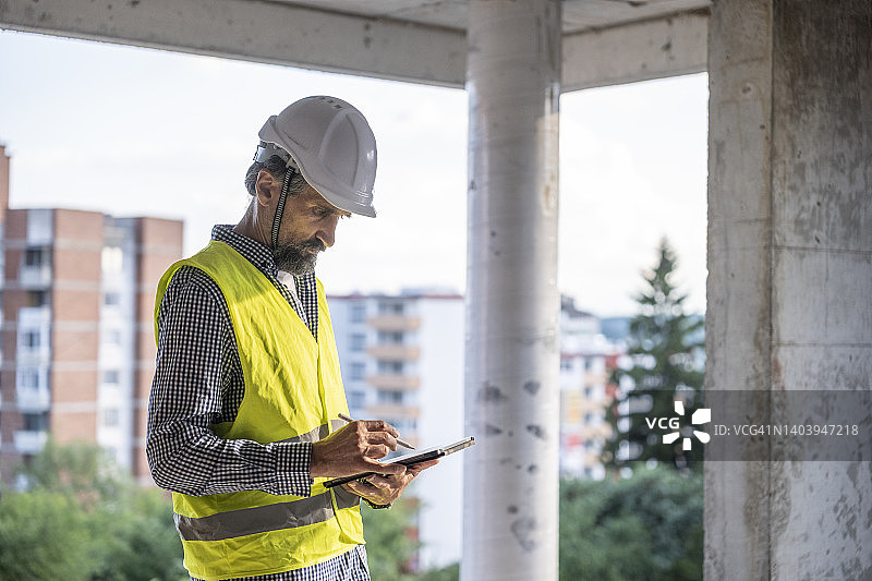土木工程师在施工现场使用平板电脑检查工作进度图片素材