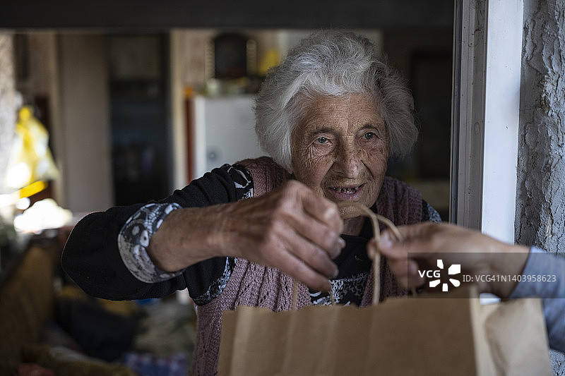年轻志愿者为居家老人送食物图片素材