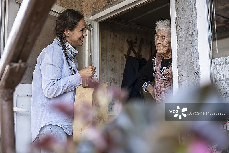 年轻志愿者为居家老人送食物图片素材