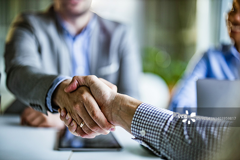 商务人士在办公室达成协议的特写图片素材