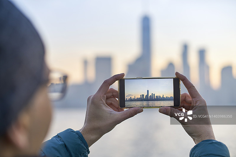 游客用智能手机拍摄美国纽约曼哈顿天际线图片素材