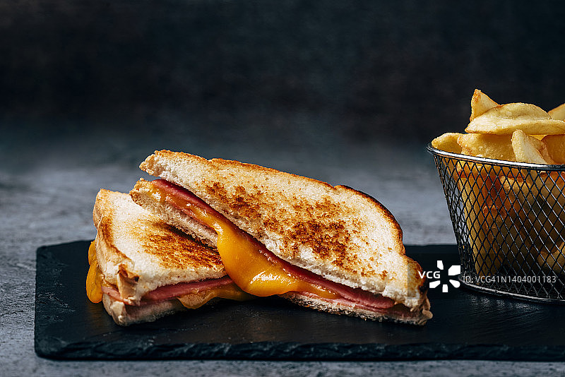火腿和融化的奶酪三明治，配一份炸薯条图片素材