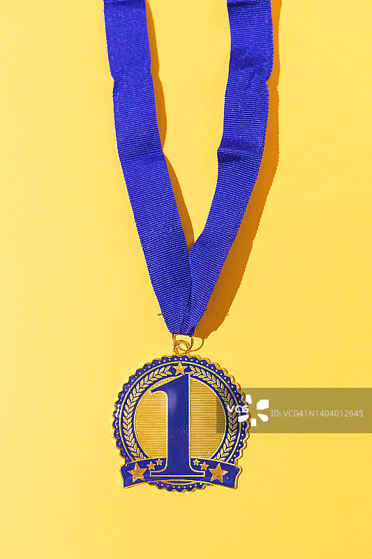 黄色背景上的蓝色装饰一等功体育金牌图片素材
