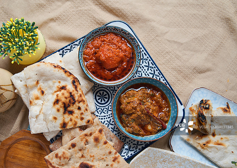 印度薄饼配黄油鸡肉和红咖喱牛肉图片素材