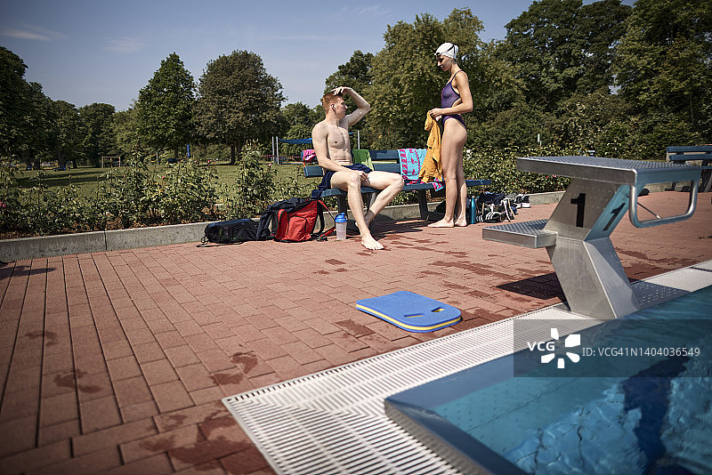 在公共泳池长椅上的男人和女人图片素材