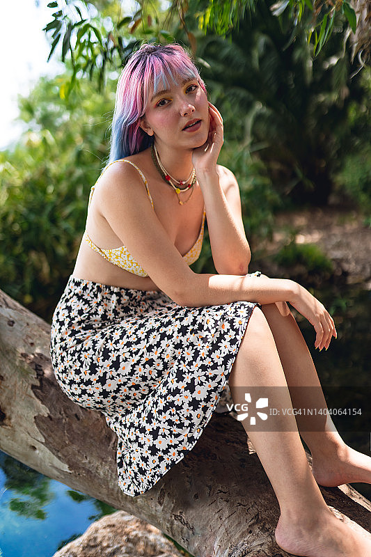 在湖边树旁休息的彩色头发年轻女人肖像图片素材