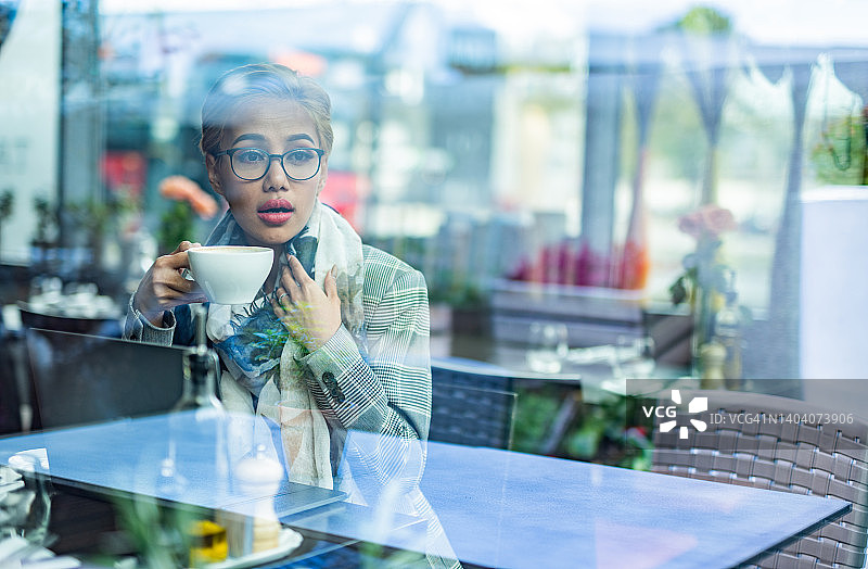 透过咖啡馆的窗户看女人图片素材