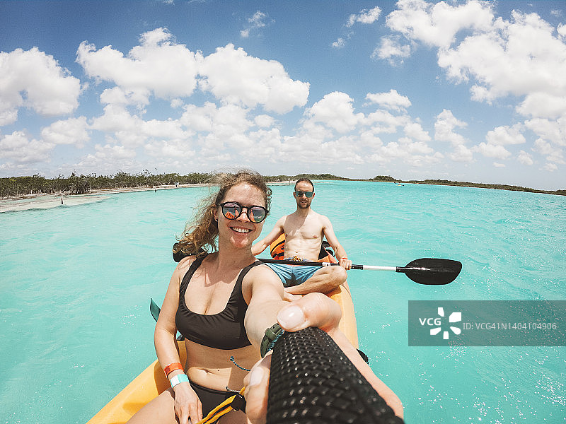 情侣在巴卡拉尔湖上划皮划艇时自拍图片素材