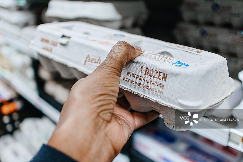 在超市拿起一盒鸡蛋的女人图片素材