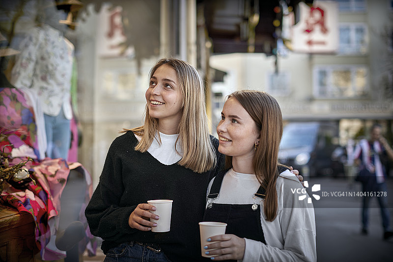在城市里看着商店橱窗的两个女人图片素材
