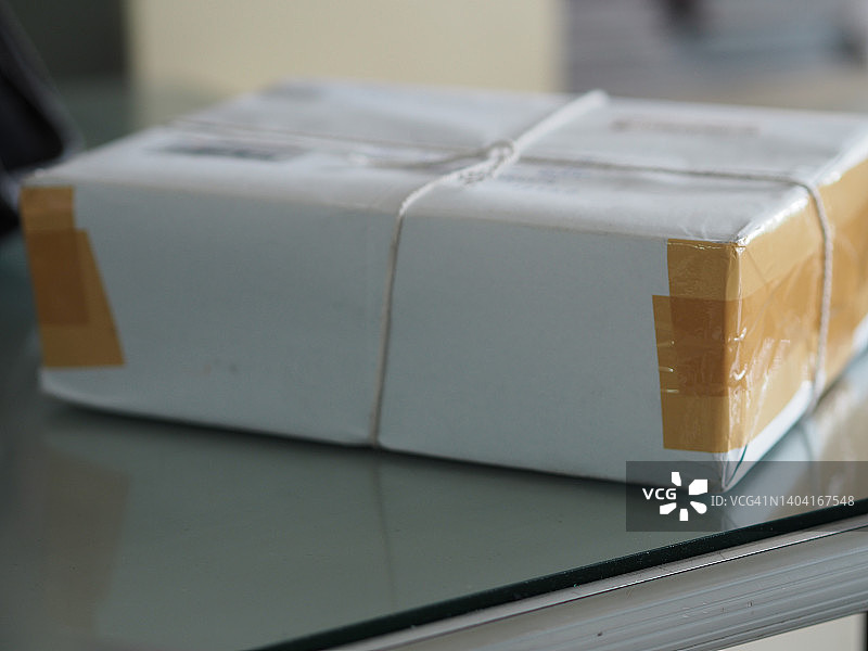 白色包装纸爱心包裹，桌子上的棕色胶带图片素材