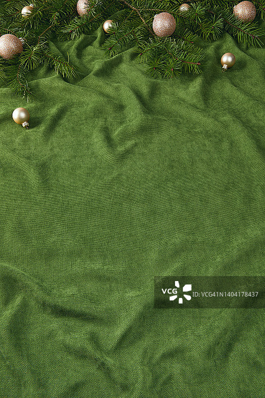 带有米色圣诞饰品的圣诞静物背景，饰品在折叠的绿色天鹅绒上图片素材