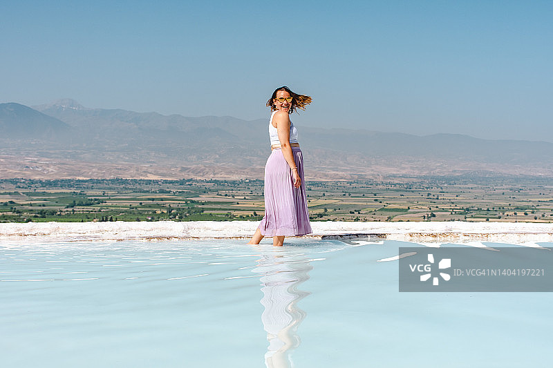 在帕穆克卡莱石灰华池的年轻女子图片素材