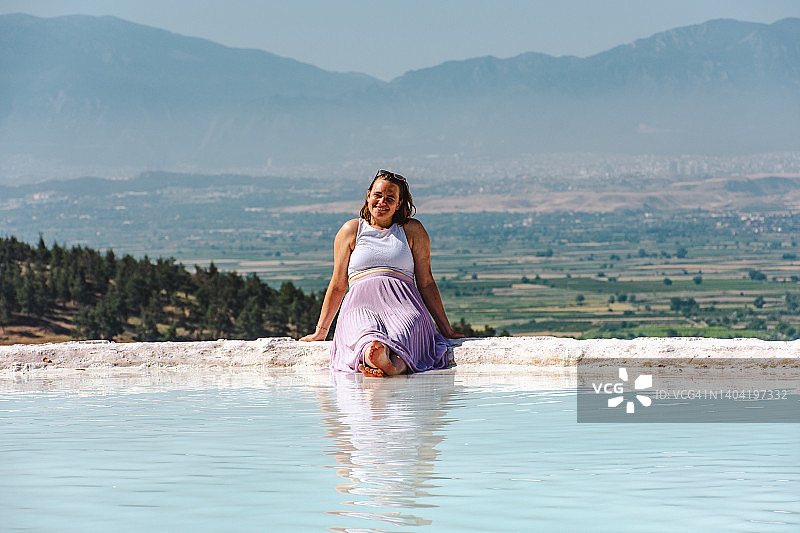 在帕穆克卡莱石灰华池的年轻女子图片素材