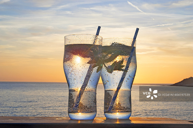 日落时海岸边的碳酸水品脱杯图片素材