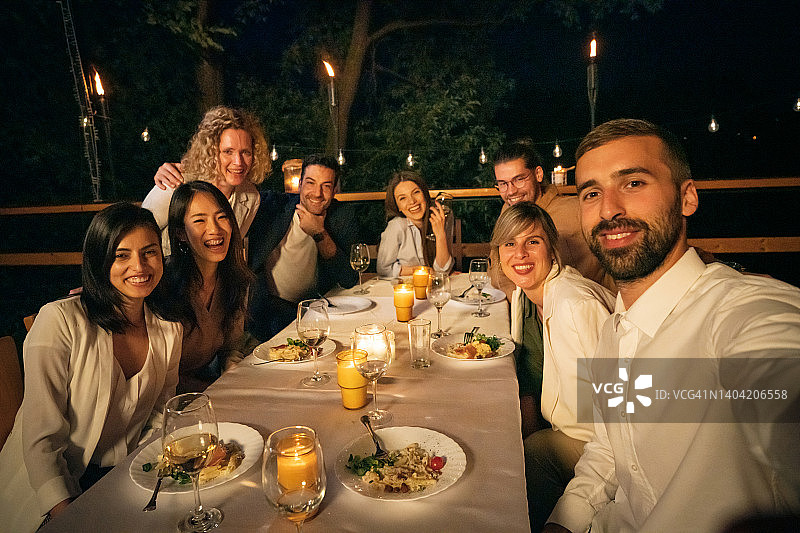 多元种族男女朋友在餐厅阳台用餐时自拍图片素材