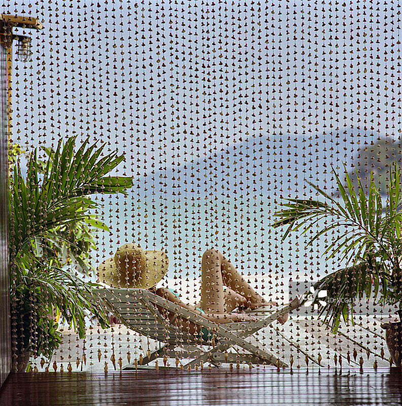 女游客在海滩的躺椅上放松身心图片素材