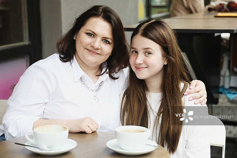 母亲节：少女与母亲在城市咖啡馆放松身心图片素材