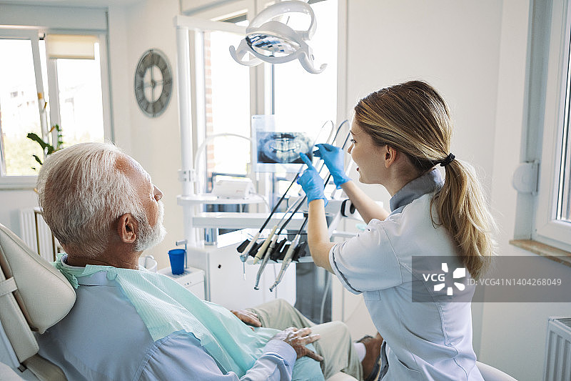 牙医正在检查老年男性的X光牙齿影像图片素材