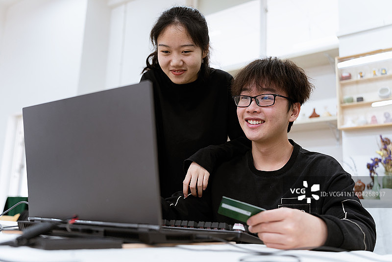 年轻亚洲夫妇使用电脑进行网上购物图片素材